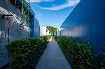 a sidewalk between two buildings with a blue wall at Villa 2 Bedrooms with private pool at Wings Pasak in Bang Tao Beach