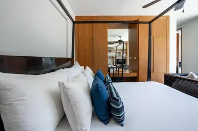 a bedroom with a white bed with blue pillows at Villa 3 Bedrooms with private pool at Wings Pasak in Bang Tao Beach