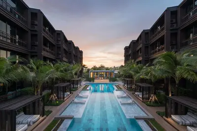 an image of a swimming pool at a resort with palm trees at Saturdays Residence - 1 Bedroom Service Apartment in Rawai Beach