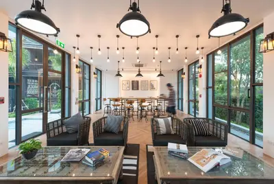 a room with a table and chairs and windows at Saturdays Residence - 2 Bedrooms Service Apartment in Rawai Beach