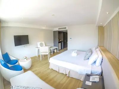 a hotel room with a bed and a table and chairs at Hiran Residence in Patong Beach
