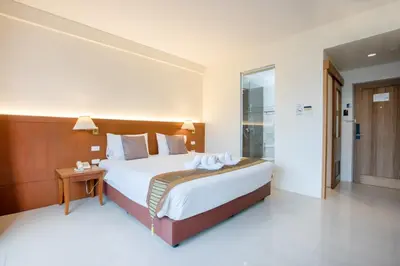 a bedroom with a large bed with a wooden headboard at Orchid Garden Hotel Patong in Patong Beach