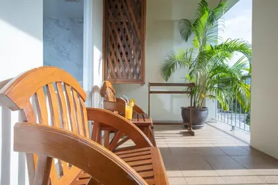 a dining room with a table and chairs and a palm tree at Orchid Garden Hotel Patong in Patong Beach