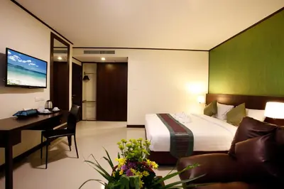 a hotel room with a bed and a desk and a couch at Orchid Resortel in Patong Beach