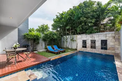 a swimming pool with a table and chairs next to a house at Trixie Town House 3 With Private Pool in Rawai Beach