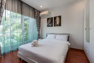 a bedroom with a bed with a teddy bear on it at Trixie Town House 3 With Private Pool in Rawai Beach