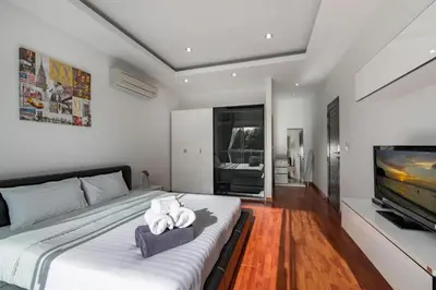 a bedroom with a large bed and a television at Trixie Town House 3 With Private Pool in Rawai Beach