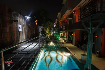 an empty swimming pool at night with two mermaids in it at Nicky's Handlebar in Patong Beach