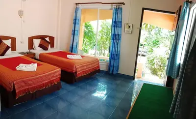 a hotel room with two beds and a window at Anawin Bungalows in Ao Nang Beach