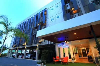a hotel with red chairs in front of a building at Cool Residence Hotel in Phuket Town