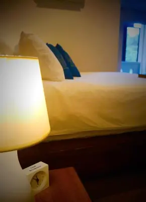 a bedroom with a bed with a lamp and a clock at Cool Residence Hotel in Phuket Town
