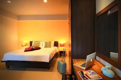 a bedroom with a bed and a laptop on a desk at Cool Residence Hotel in Phuket Town
