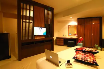 a bedroom with a laptop on a bed with a television at Cool Residence Hotel in Phuket Town
