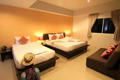 a hotel room with two beds and a couch at Cool Residence Hotel in Phuket Town