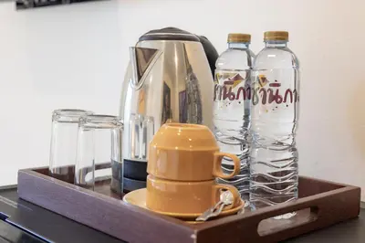 a wooden tray with bottles of water and a blender at Baan Yuyen Karon Guesthouse in Karon Beach