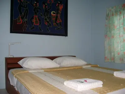 a bedroom with a bed with two towels on it at Pineapple Guesthouse in Karon Beach