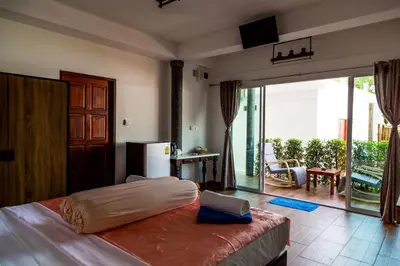 a bedroom with a bed and a large sliding glass door at Yao Yai Beach Resort in Ko Yao Yai
