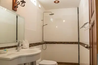a bathroom with a shower and a sink and a toilet at Yao Yai Beach Resort in Ko Yao Yai