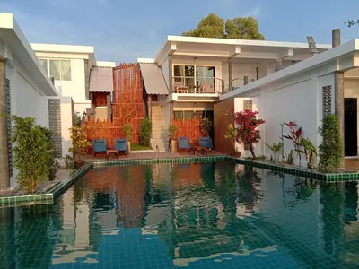 a house with a swimming pool in front of a house at Yao Yai Beach Resort in Ko Yao Yai