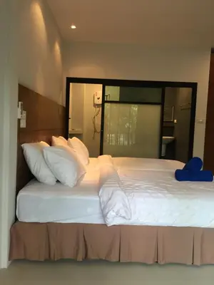 a bedroom with a large bed with white sheets and pillows at Anattaya Holiday Home in Ko Yao Noi