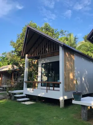 a tiny house with a picnic table and benches at Anattaya Holiday Home in Ko Yao Noi
