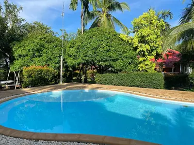 a blue swimming pool in a yard with trees at Krabi Discovery Resort in Tha Lane Bay