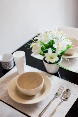 a table with plates and bowls and a vase of flowers at Phuket Town 1 Bedroom Condo Luxury Facilities, The Base Downtown in Phuket Town