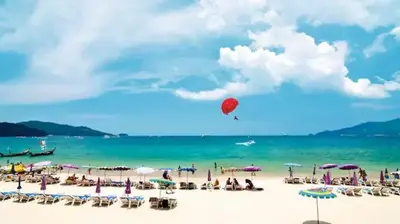 a group of people on a beach with a red balloon at Luxury Beach Apartments by MVP in Patong Beach