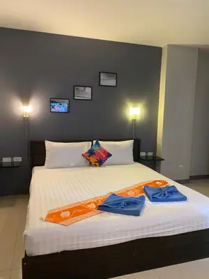 a bedroom with a large bed with two robes on it at Holiday Home Patong in Patong Beach
