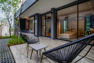 a patio with two chairs and a bench at The Woods Natural Park Resort Phuket in Kamala Beach