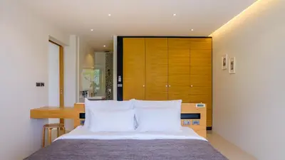a bedroom with a large bed with white pillows at The Woods Natural Park Resort Phuket in Kamala Beach