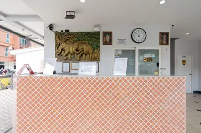 a counter in a room with a clock on the wall at Square One Hotel Patong in Patong Beach