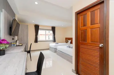 a hotel room with a bed and a television at Square One Hotel Patong in Patong Beach