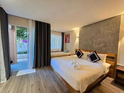 a bedroom with a large bed with a large window at TT Naiyang Beach Phuket in Nai Yang Beach