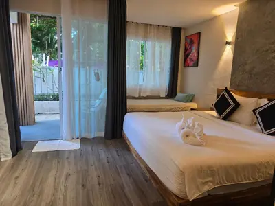 a hotel room with two beds and a window at TT Naiyang Beach Phuket in Nai Yang Beach