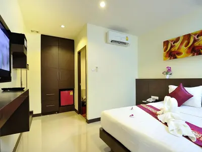 a bedroom with a bed and a flat screen tv at Pimrada Hotel in Patong Beach