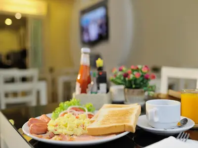 a plate of food on a table with a sandwich and toast at Pimrada Hotel in Patong Beach