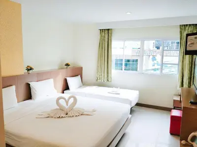 a bedroom with two beds with a heart decoration on them at Pimrada Hotel in Patong Beach