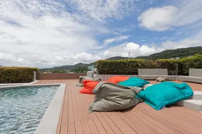 a group of pillows laying on a deck next to a pool at 6-Ave Surin Apartment in Surin Beach