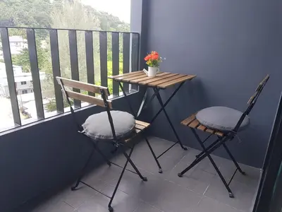 a small table and two chairs on a balcony at 6-Ave Surin Apartment in Surin Beach