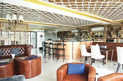 a restaurant with a bar with leather chairs and tables at 6-Ave Surin Apartment in Surin Beach