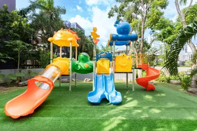 a playground with different types of play equipment on grass at Andaman Embrace Patong, Phuket in Patong Beach