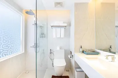 a bathroom with a shower and a toilet and a sink at Andaman Embrace Patong, Phuket in Patong Beach
