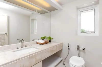 a bathroom with a sink and a toilet and a window at Andaman Embrace Patong, Phuket in Patong Beach
