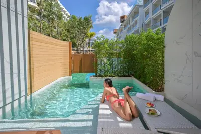 a woman in a bikini laying in a swimming pool at Andaman Embrace Patong, Phuket in Patong Beach