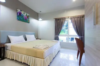 a bedroom with a bed and a window at Sandy House Rawai in Rawai Beach