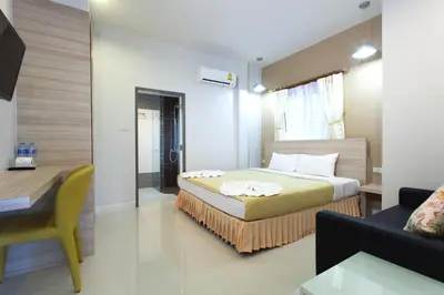 a bedroom with a bed and a desk and a couch at Sandy House Rawai in Rawai Beach