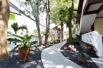 a walkway with potted plants on the side of a house at Sandy House Rawai in Rawai Beach