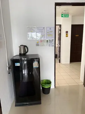 a black refrigerator with a kettle on it in a hallway at Happy Fish Guesthouse in Patong Beach