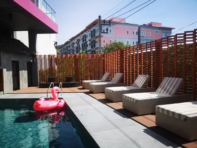 a pool with lounge chairs and a flamingo in the water at De Cozé Hotel in Patong Beach